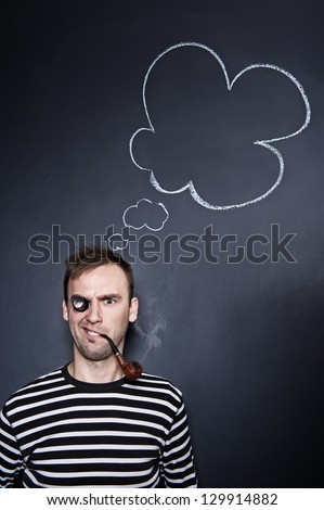 sailor with a thought cloud on the blackboard wall behind him