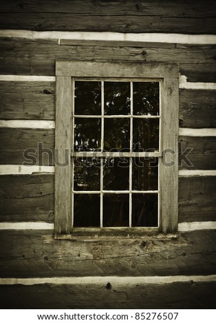 Old log cabin wall and window. Rustic and abandoned.