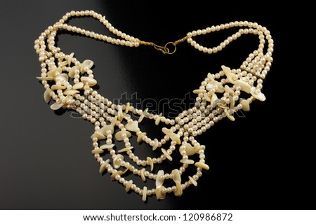 A necklace of artificial pearls with mother-of-pearl pieces.