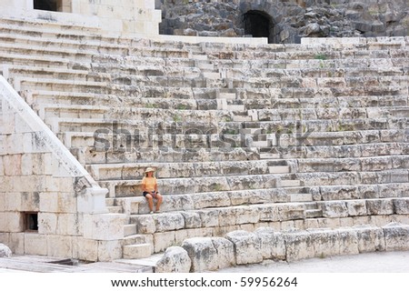 A woman is sitting on the steps of the ancient Roman amphitheater in the city of Beit-Shean, Israel