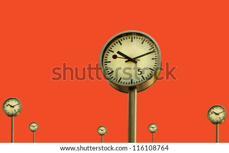 Clocks in Canary Wharf in London\'s financial district, isolated on red surface.
