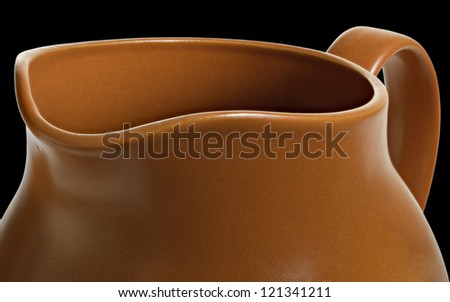 Part of clay pot for water or milk isolated on black surface.