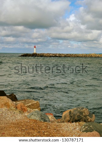 Sea landscape with lighthouse on the mole.