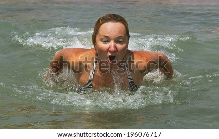 Woman is recreation on beach in warm water.