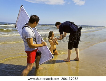 LATVIA - JULY 10: photographers and model on the beach in a sunny day. Photo session along the coast of Baltic sea in Latvia, Jurmala on July 10, 2014.