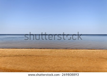 Smooth water of Baltic sea and gold sand.