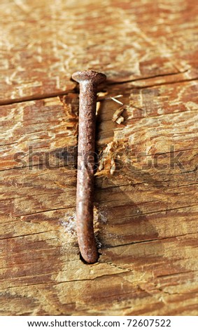 Rusty nail in obsolete wood plank, vertical photo.