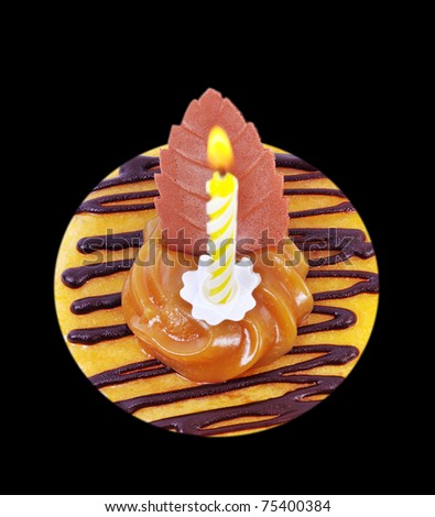 Cake with yellow candle isolated on black surface.