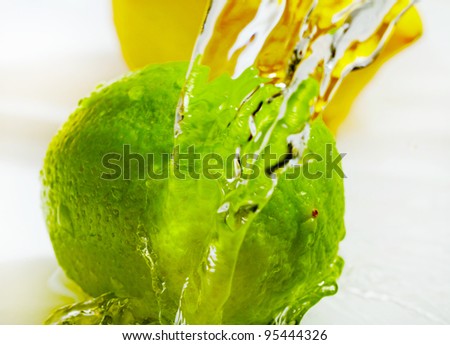 Fruits washing, water splash above ripe lemon and lime.