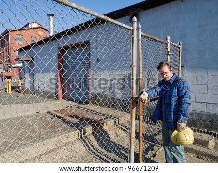 Male Construction Worker, forlorn, outdoors, out of work , locked out, factory