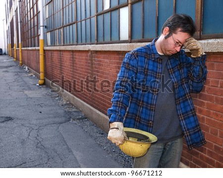 Male Construction Worker, forlorn, outdoors, out of work in alley