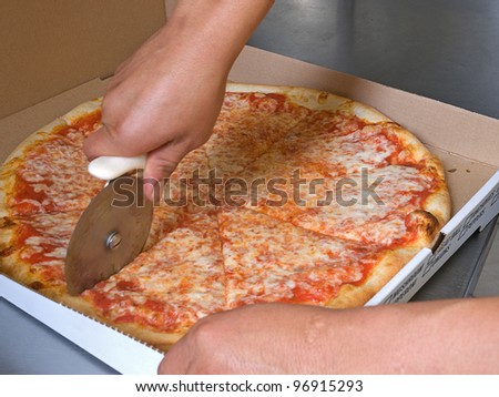 Pizza Making - cutting the pizza pie with a rolling cutter,
