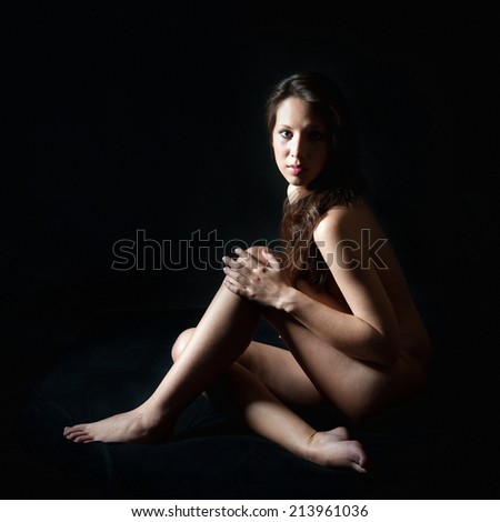 Sensual portrait of a beautiful nude woman, high contrast, photo in front of black background