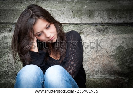Outdoor portrait of a sad teenage girl looking thoughtful about troubles