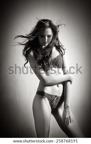 Fashion portrait of an attractive woman wearing lingerie, monochrome photo with high contrast
