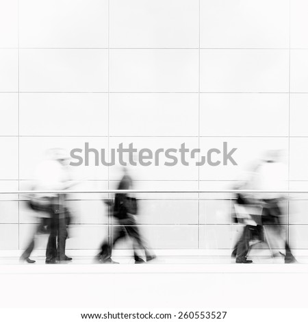 Unrecognizable business people in a fair hall, intentional motion blur, monochrome photo