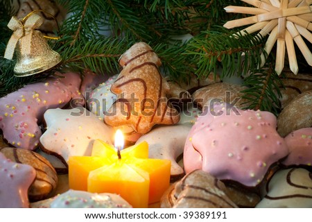 Christmas cookies with fir branches, straw star, bell and candle