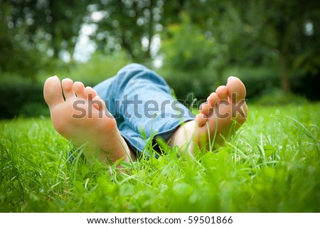 stock photo Feet of a sexy young woman lying in the grass