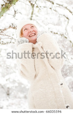 Winter portrait of a laughing young woman in the snow