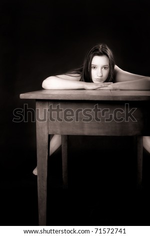 stock photo Portrait of a beautiful nude woman bending over an old wooden 