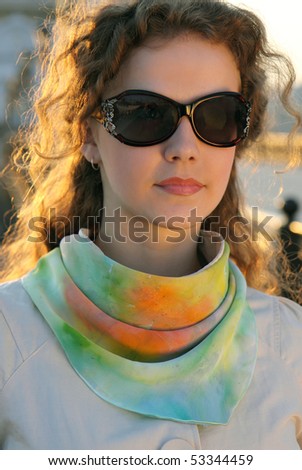 Pretty young woman wearing sunglasses and having a walk in the city