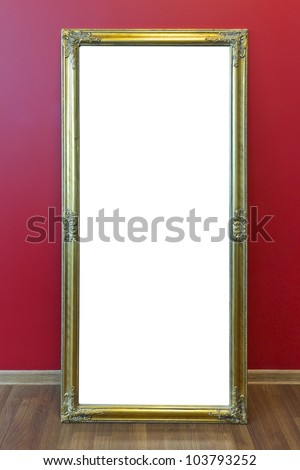 Yellow plastic mass production frame from  large mirror stand  against a red office wall. With patch