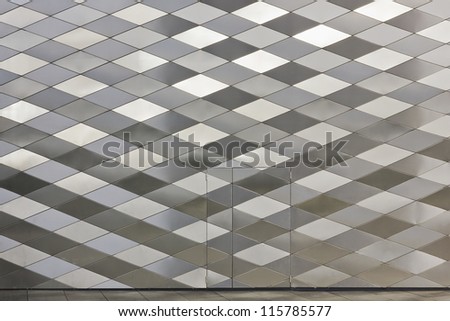 Wall and the front door of the metal silver diamond-shaped panels construction background