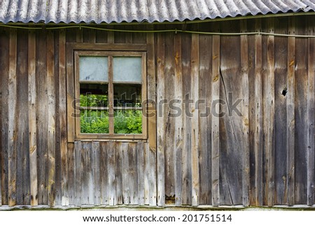 Green grass grows behind a window in the wooden wall concept
