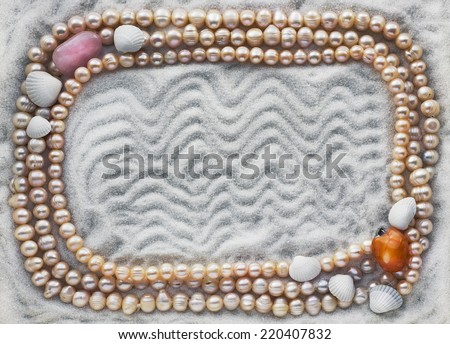 The necklace from pink and yellow pearls lies on white sea quartz sand background