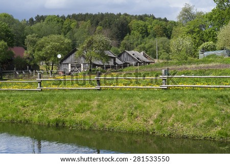 Retro wooden European village on lake bank spring landscape