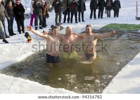 VILNIUS, LITHUANIA - FEBRUARY 4: Fans of winter swimming take a bath in some ice water on February 4, 2012 in Vilnius, Lithuania.  -20 Celsius degrees.Smiling members of the club fans of ice water