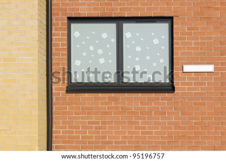 Plastic mass production window is decorated with paper snowflakes-  Christmas window concept. Sunny day