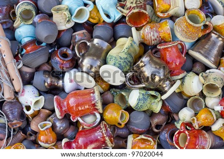 Background from small ceramic multi-colored jugs and cups. STrong selective focus. Mass production