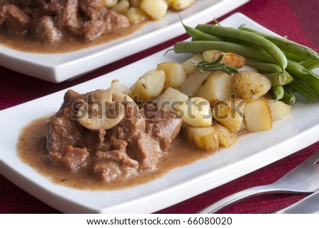 Beef steaks in Italian sauce with roasted potatoes, green beans and rosemary