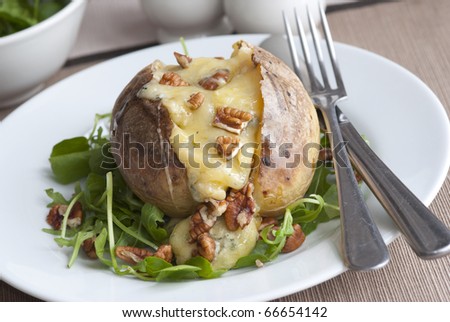 Jacket potato filled with melted cheese and walnuts
