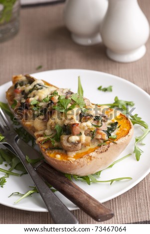 Baked butternut squash filled with spinach, bacon and cheese