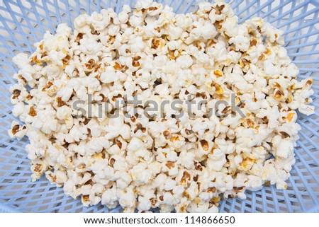 Salted popcorn grains in a plastic bowl