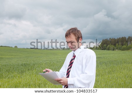 Farmer calculating earning in field.