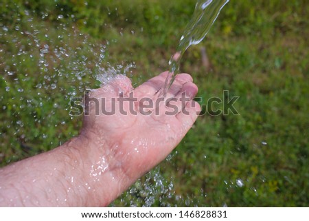 Hand and water on green.