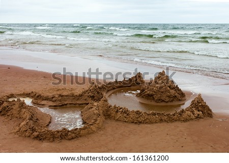 Sandcastle in storm at baltic coast.