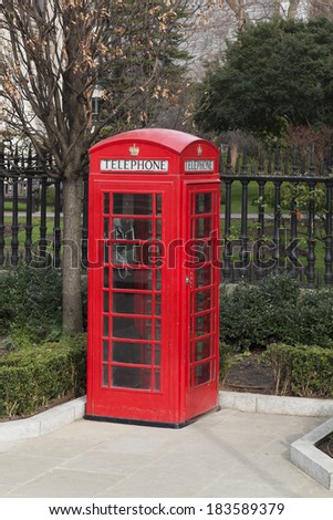 Red phone booth in park, London. UK.