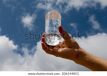 Glass of water in human hand.