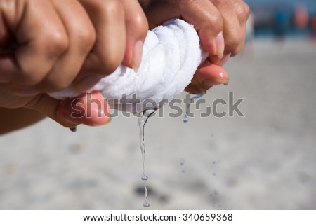 Hands squeeze wet white towel.