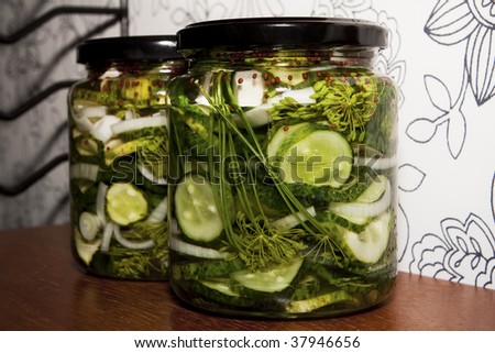 Pickled cucumbers in cans on a wooden shelf.