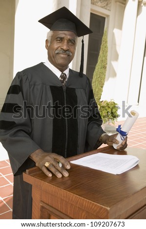 Portrait of a senior dean standing at podium on the graduation ceremony