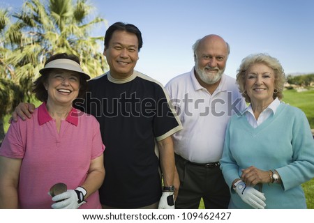 Group portrait of multiethnic golfers standing together