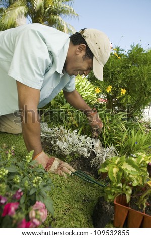 Happy mature man gardening in the garden