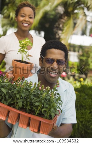 Happy African American man and woman working in the garden