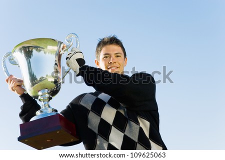 Young man holding trophy on golf course