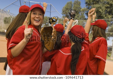 Excited young softball player with team after a winning game